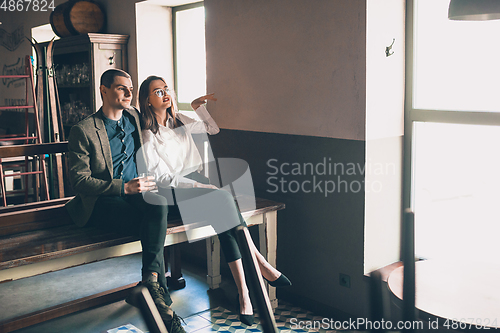 Image of Cheerful man and woman talking, enjoying, having fun at bar, cafe