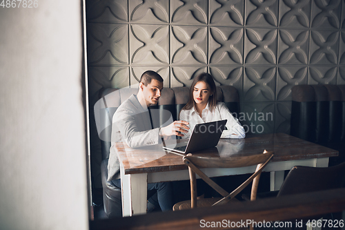 Image of Cheerful man and woman talking, working at the coffee shop, cafe