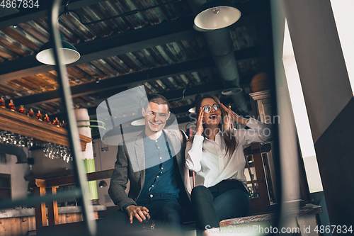 Image of Cheerful man and woman talking, enjoying, having fun at bar, cafe