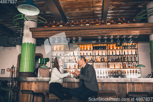 Image of Cheerful man and woman talking, enjoying a coffee at the coffee shop, cafe, bar