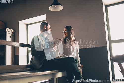 Image of Cheerful man and woman talking, enjoying, having fun at bar, cafe