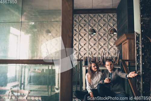 Image of Cheerful man and woman talking, enjoying, having fun at bar, cafe