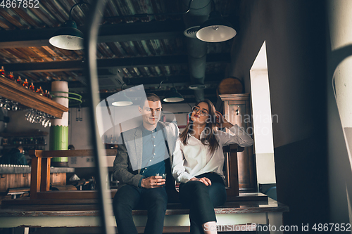 Image of Cheerful man and woman talking, enjoying, having fun at bar, cafe