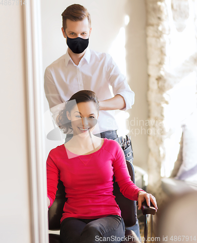 Image of happy woman with stylist making hairdo at salon