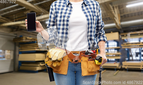 Image of female worker with phone and tools at factory