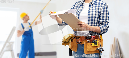 Image of woman with clipboard, pencil and working tools