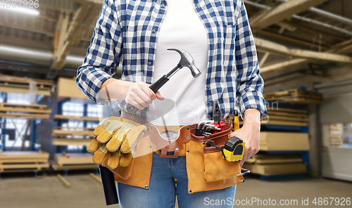 Image of female worker with hammer and tools on belt