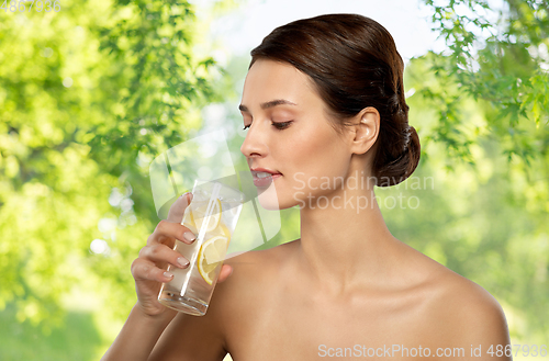 Image of woman drinking water with lemon and ice
