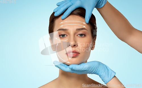 Image of beautiful young woman face and hand in gloves