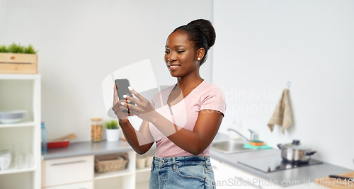 Image of happy african american woman using smartphone