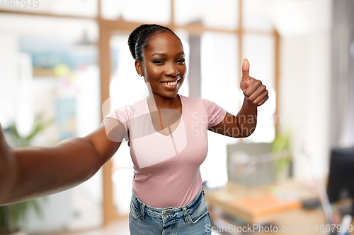 Image of african woman taking selfie and showing thumbs up