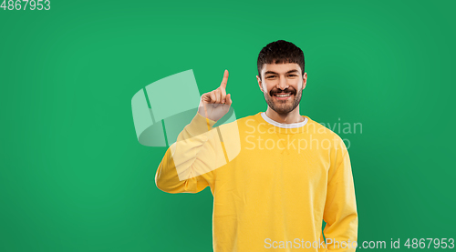 Image of happy man pointing finger up over green