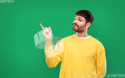 Image of man pointing finger to something over green