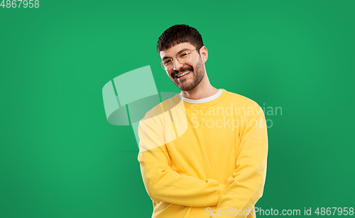 Image of smiling young man in glasses and yellow sweatshirt