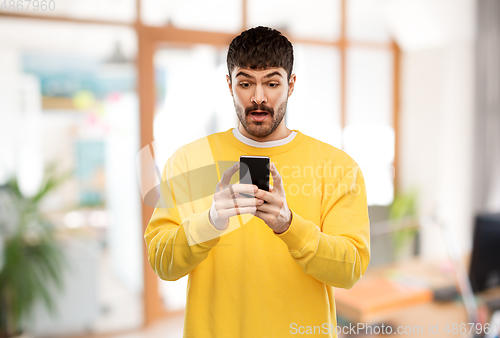 Image of surprised young man with smartphone