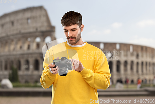 Image of young man with digital camera over coliseum