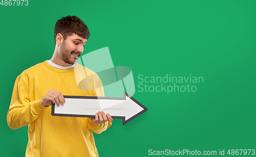Image of smiling man pointing big arrow to right over green