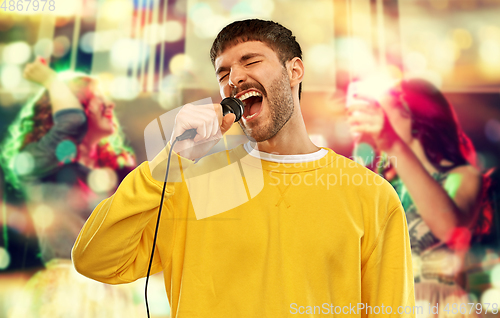 Image of man with microphone singing at night club