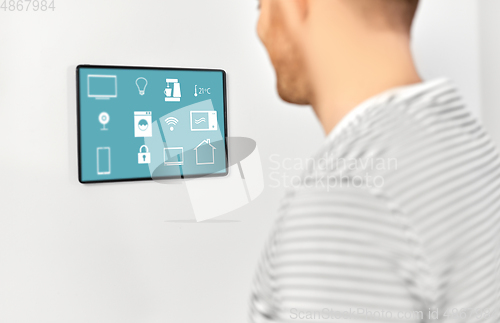 Image of happy man looking at tablet computer at smart home