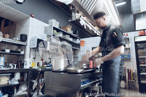 Image of Behind the scenes of brands. The chef cooking in a professional kitchen of a restaurant meal for client or delivery. Motion.