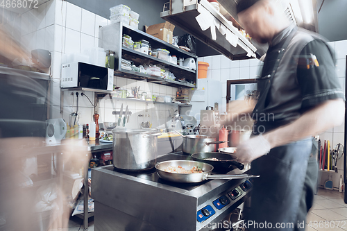 Image of Behind the scenes of brands. The chef cooking in a professional kitchen of a restaurant meal for client or delivery. Motion.