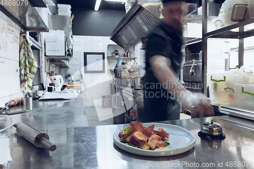 Image of Behind the scenes of brands. The chef cooking in a professional kitchen of a restaurant meal for client or delivery. Motion.