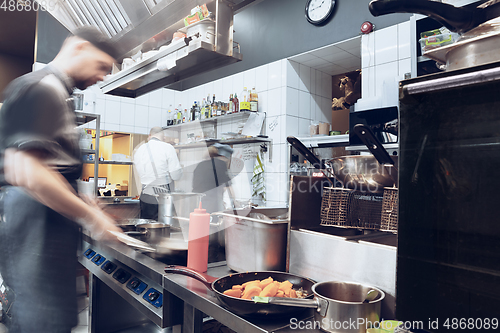 Image of Behind the scenes of brands. The chef cooking in a professional kitchen of a restaurant meal for client or delivery. Motion.