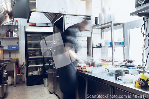 Image of Behind the scenes of brands. The chef cooking in a professional kitchen of a restaurant meal for client or delivery. Motion.