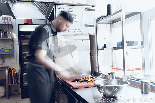 Image of Behind the scenes of brands. The chef cooking in a professional kitchen of a restaurant meal for client or delivery. Motion.