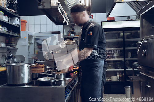 Image of Behind the scenes of brands. The chef cooking in a professional kitchen of a restaurant meal for client or delivery. Motion.