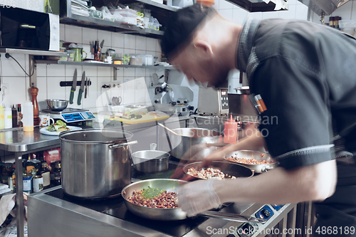 Image of Behind the scenes of brands. The chef cooking in a professional kitchen of a restaurant meal for client or delivery. Motion.