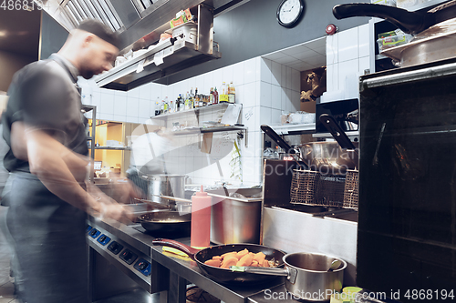 Image of Behind the scenes of brands. The chef cooking in a professional kitchen of a restaurant meal for client or delivery. Motion.