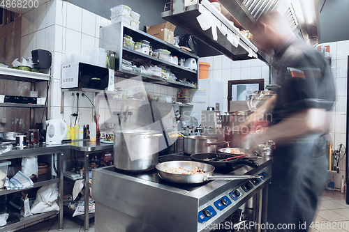 Image of Behind the scenes of brands. The chef cooking in a professional kitchen of a restaurant meal for client or delivery. Motion.