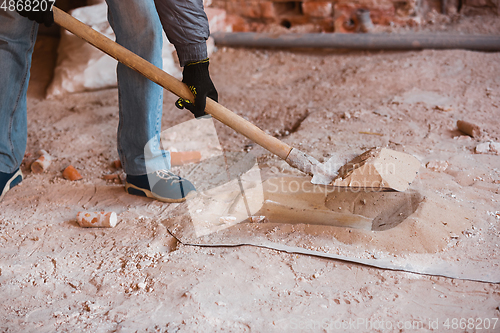 Image of Close up of hand of repairman, professional builder working indoors, repairing