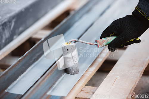 Image of Close up of hand of repairman, professional builder working indoors, repairing