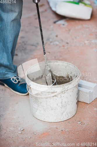 Image of Close up of hand of repairman, professional builder working indoors, repairing