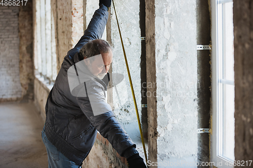 Image of Close up of hand of repairman, professional builder working indoors, repairing