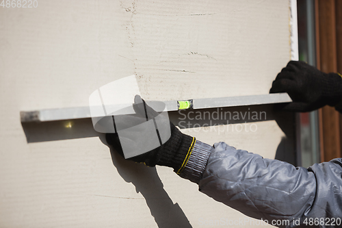 Image of Close up of hand of repairman, professional builder working indoors, repairing