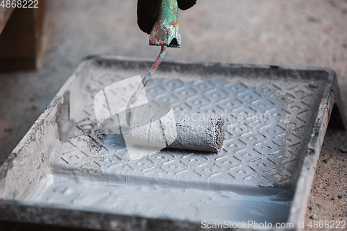 Image of Close up of hand of repairman, professional builder working indoors, repairing