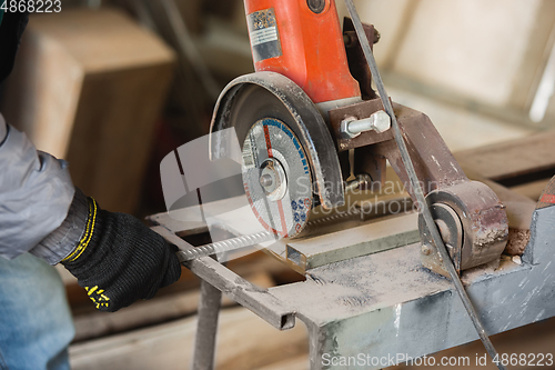 Image of Close up of hand of repairman, professional builder working indoors, repairing