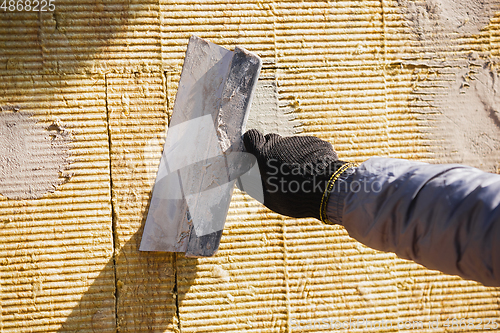 Image of Close up of hand of repairman, professional builder working indoors, repairing