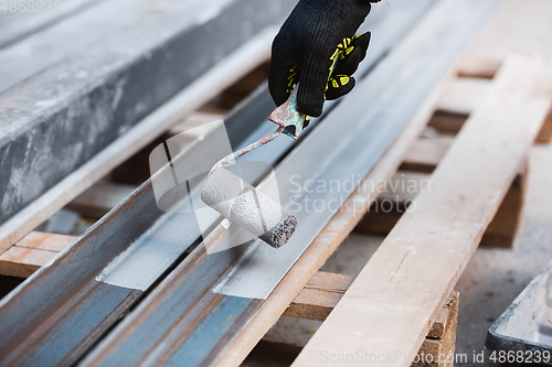 Image of Close up of hand of repairman, professional builder working indoors, repairing