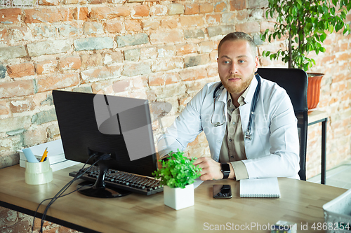 Image of Caucasian doctor consulting for patient, working in cabinet