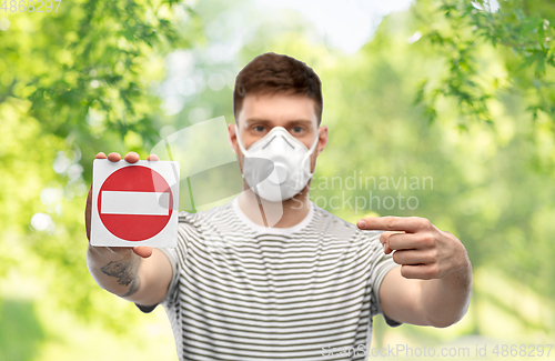 Image of man in respirator mask showing stop sign