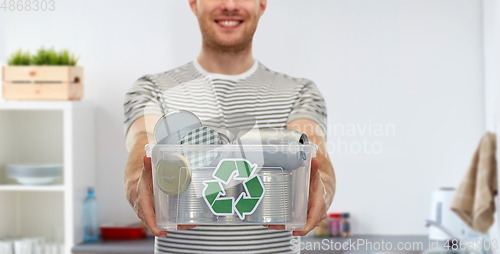 Image of smiling young man sorting metallic waste