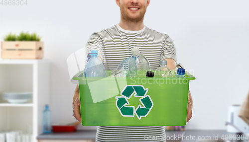 Image of smiling young man sorting plastic waste