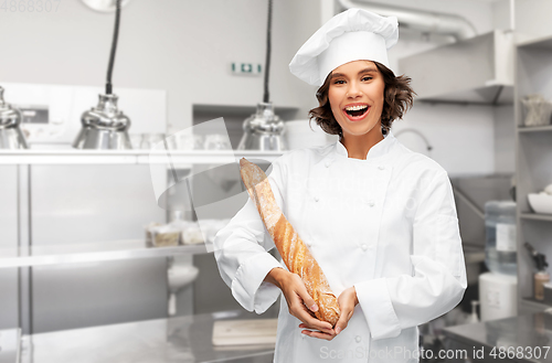 Image of happy female chef with french bread or baguette