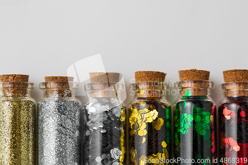 Image of set of glitters in bottles over white background