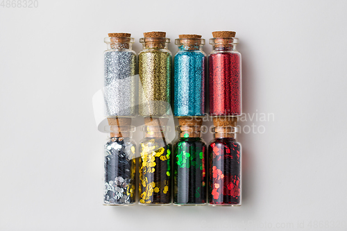 Image of set of glitters in bottles over white background