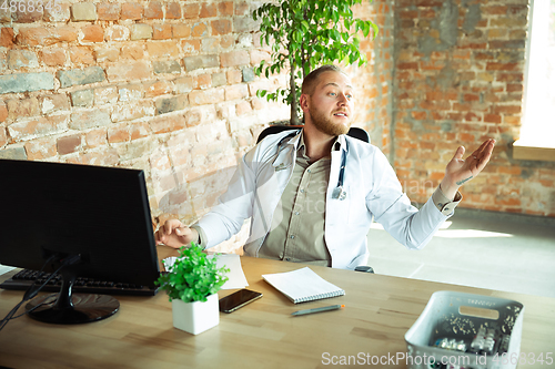 Image of Caucasian doctor consulting for patient, working in cabinet